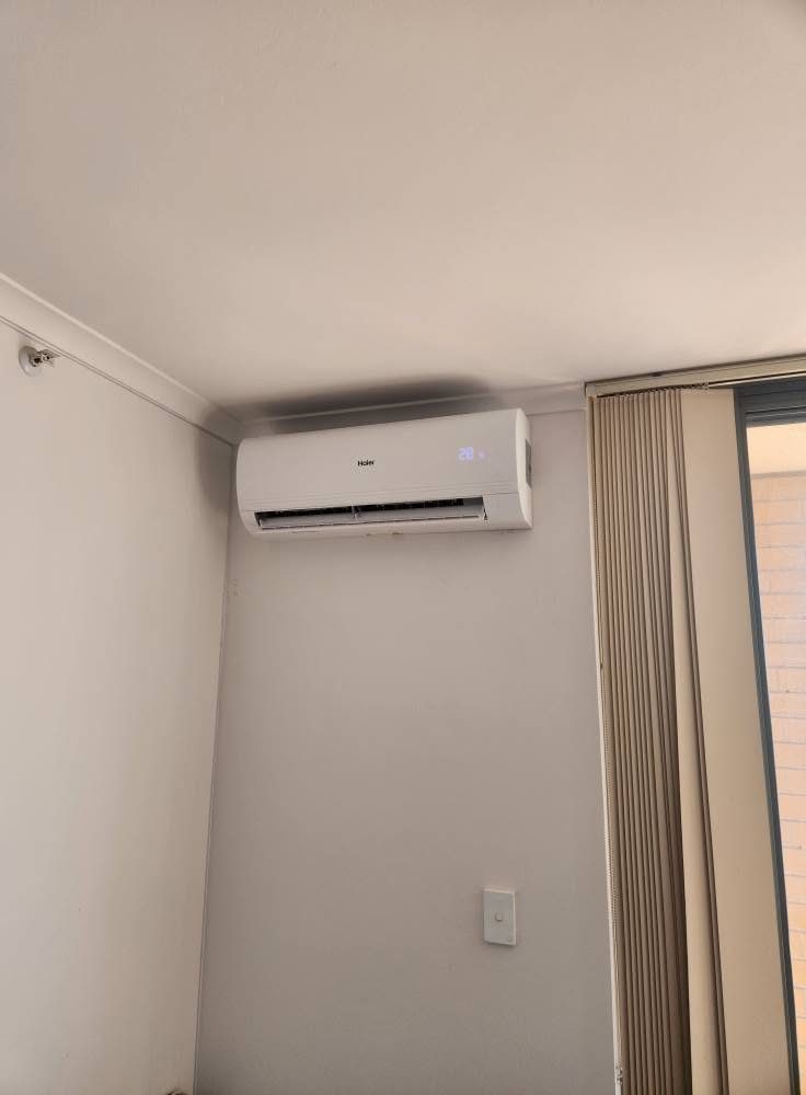 Wall-mounted split system indoor unit in a freshly painted room